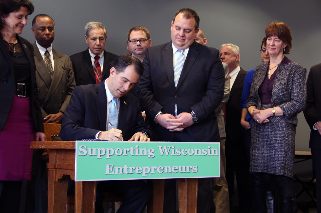 Wisconsin Gov. Scott Walker signs Assembly Bill 350, his state's crowdfunding bill, on Nov. 7, 2013 at University Research Park in Madison, Wis. | Photo by Allen Wagner
